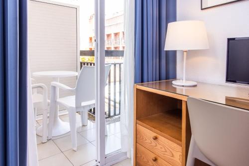 a room with a desk and a window with a table at RVHotels Mar de Tossa in Tossa de Mar