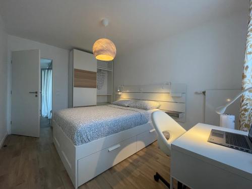 a bedroom with a bed and a desk with a laptop at Apartment near to Paris CDG in Aulnay-sous-Bois