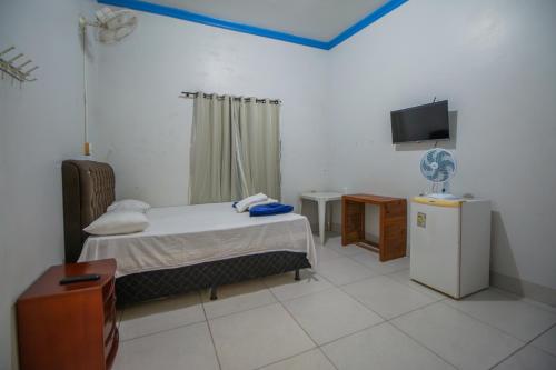 a bedroom with a bed and a tv in it at Hotel Pousada Zacarias in Anápolis