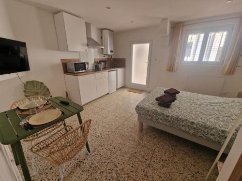 Cette chambre comprend un lit, une table et une cuisine. dans l'établissement Cozy & modern renovated studio in the heart of L'Écusson, à Montpellier