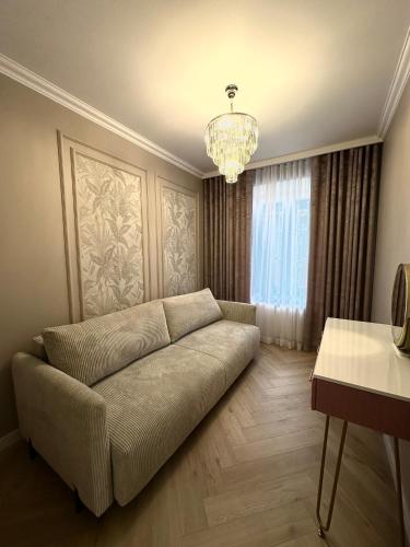 a living room with a couch and a chandelier at Premium Park Apartament in Kielce