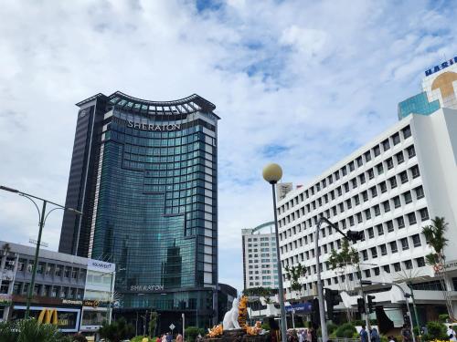 a tall building in the middle of a city at Riverbank Suites Kuching Waterfront in Kuching