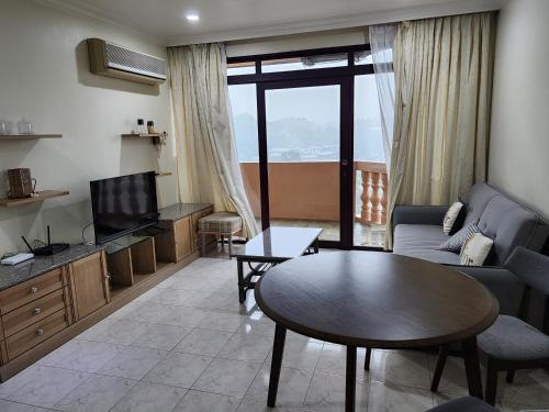 a living room with a couch and a table at Riverbank Suites Kuching Waterfront in Kuching
