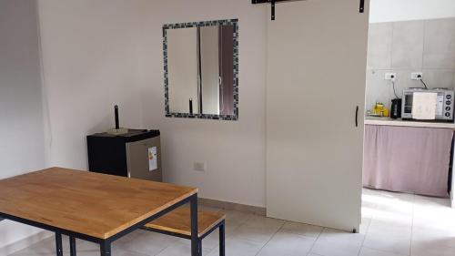 a kitchen with a table and a mirror on the wall at Pisadas II Rivadavia 532 in Río Colorado