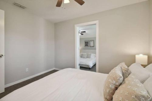 a white bedroom with a bed and a ceiling fan at Comfortable Home in Dade City! in Dade City