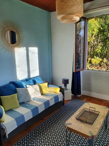 un salon avec un canapé et une fenêtre dans l'établissement La Maison au Tilleul, à Labarthe-Bleys