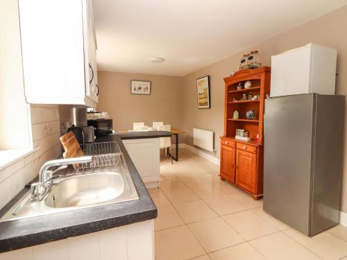 a kitchen with a sink and a refrigerator at O'Connell's&nbspLodge in Portmagee