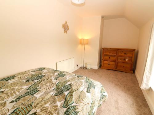 a bedroom with a bed and a dresser at O'Connell's&nbspLodge in Portmagee
