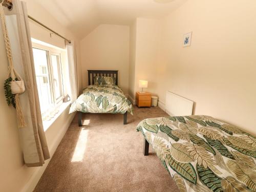 a bedroom with a bed and a window at O'Connell's&nbspLodge in Portmagee