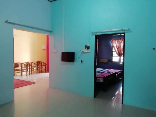Kota BharuにあるUMARI WEDDING HOMESTAY & SPA CONCEPT in KOTA BHARUのドア付きの部屋とベッド付きの部屋