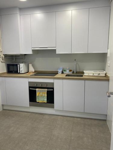 a kitchen with white cabinets and a stove at Casa esperanza in Soria