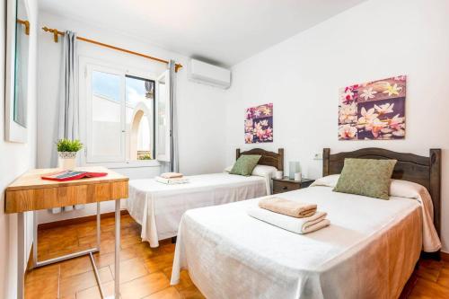 カラン・ボッシュにあるVilla Petunia by Villa Plusのベッド2台とテーブルと窓のある部屋