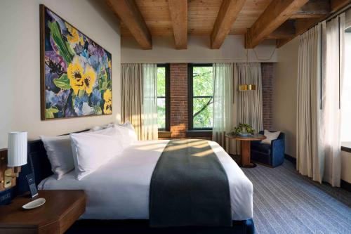 a bedroom with a large white bed and a desk at Populus Seattle in Seattle