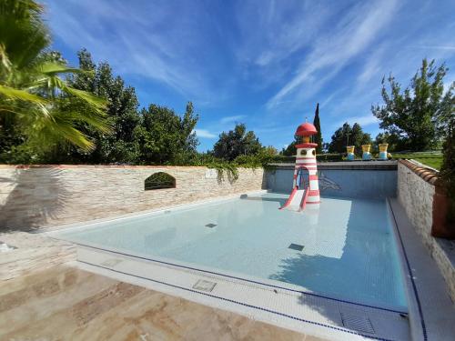 a lighthouse sits on top of a swimming pool at Camping l'Escale Mobil'home Giana in Agde