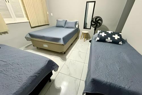 a bedroom with two beds and a mirror at Estilo e Conforto no Gonzaga – Uma Joia em Santos! in Santos