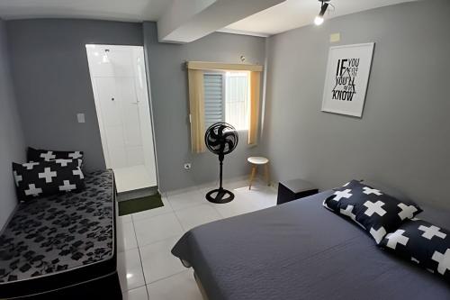 a bedroom with a bed and a fan in it at Estilo e Conforto no Gonzaga – Uma Joia em Santos! in Santos