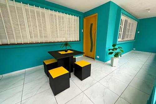 a room with blue walls and a table and chairs at Estilo e Conforto no Gonzaga – Uma Joia em Santos! in Santos