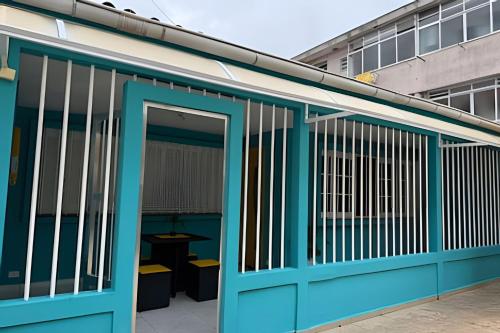 a building with a blue door with a table in it at Estilo e Conforto no Gonzaga – Uma Joia em Santos! in Santos