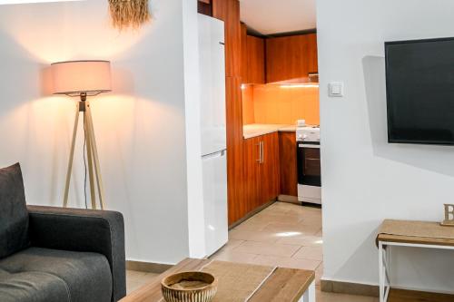 a living room with a couch and a television at Jenny Sam renovated house for 5 near center and be in Skiathos Town