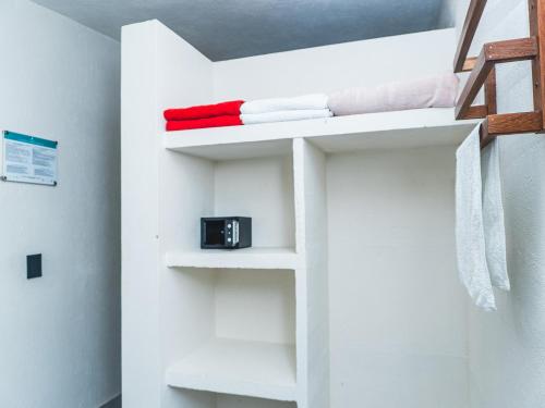 a white bunk bed with a clock on it at Huku Beach Hostel in Palomino