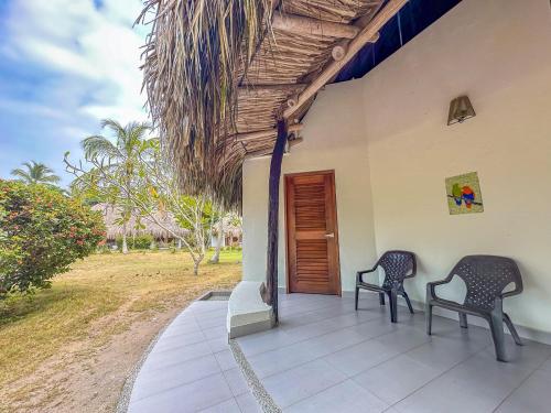 two chairs sitting on the porch of a house at Huku Beach Hostel in Palomino