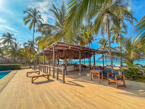 einen Pavillon mit Stühlen und Tischen am Strand in der Unterkunft Huku Beach Hostel in Palomino