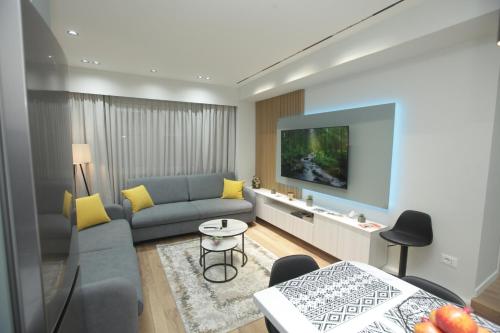 a living room with a couch and a tv at Dream House Enia 4 in Shkodër