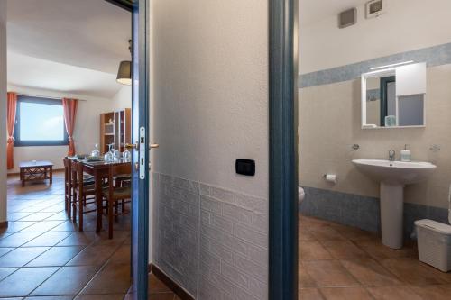 a bathroom with a sink and a toilet and a table at GuestHost - Bedà House in Porto Carollo