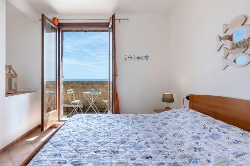 a bedroom with a bed and a view of the ocean at GuestHost - Bedà House in Porto Carollo
