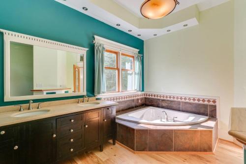 a bathroom with a tub and two sinks and a mirror at Nature Escape - Pond, Dock, Fire Pit, Trails in Paris