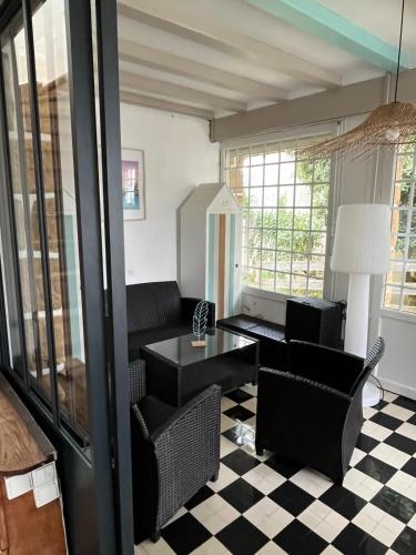 - un salon doté d'un mobilier noir et d'un sol en damier dans l'établissement Grande maison vue mer la grande plage a pied, à Quiberon