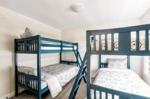 Lake of BaysShooting Star Lodge BBQ Firepit SPA Relax的一间卧室配有两张双层床和一张婴儿床。