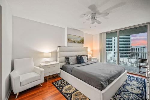 a bedroom with a bed and a chair and a window at Skyline and Bay Glimpse 1BR Brickell Retreat in Miami