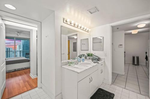 a white bathroom with two sinks and a tub at Skyline and Bay Glimpse 1BR Brickell Retreat in Miami
