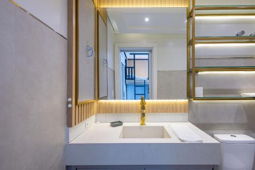 a bathroom with a sink and a mirror and a toilet at Apto 2Q c/ churrasq. prox da praia - BC - STL401 in Balneário Camboriú