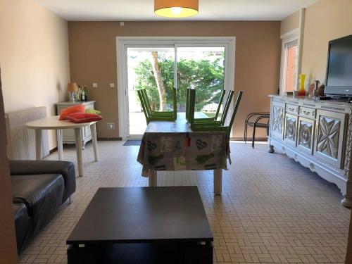 un salon avec un canapé et une table dans l'établissement Maison 2 chambres et 2 lits simple Jardin en centre ville, à Carcans