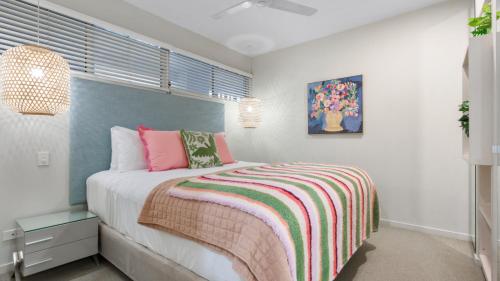 a bedroom with a bed with a colorful blanket on it at Bayside at 201 Lake Street in Cairns North