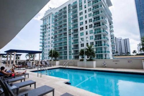 a hotel swimming pool with a large building in the background at Exclusive 2BR APT Brickell Free Parking in Miami