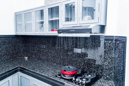 a kitchen with white cabinets and a red pot on a stove at Elegance Lake View in Habaraduwa Central