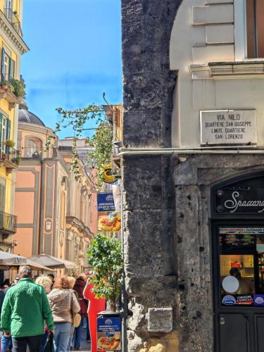 a group of people walking down a city street at NILO RELAIS a san domenico maggiore in Naples