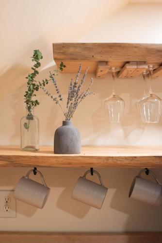 a wooden shelf with vases and glasses on it at The Nautilus at JS Hubbs Guest House in Hammondsport