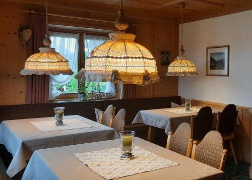 a dining room with two tables and two chandeliers at Gästehaus Annemarie in Reit im Winkl