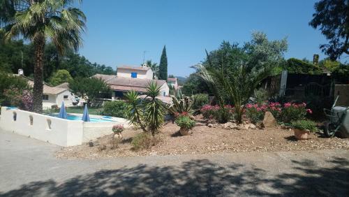 une cour avec des plantes et une piscine dans l'établissement Le mazet, à La Londe-les-Maures