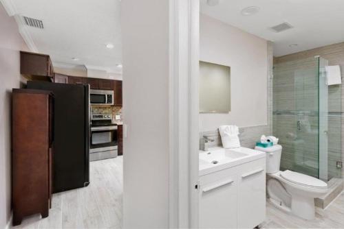 a bathroom with a toilet and a sink and a refrigerator at Beautiful Villa 4 BD 3 BA with Heated Private Pool, Close to Beach in Boca Raton