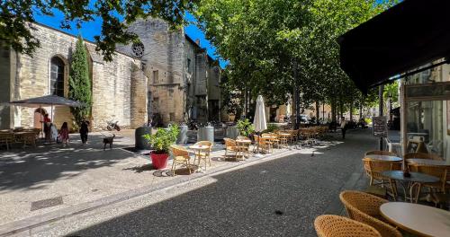 une rue avec des tables et des chaises sur un trottoir dans l'établissement Hypercenter - Wifi - Near Place des Corps Saints, à Avignon
