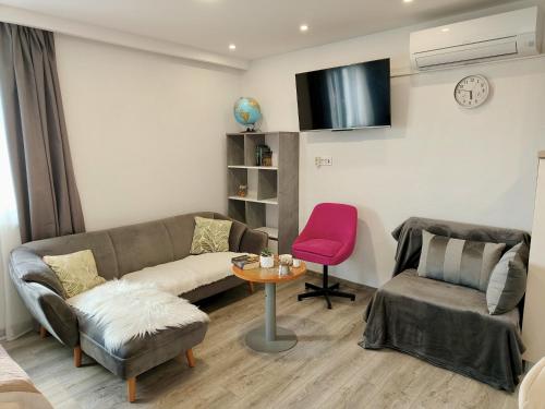 a living room with a couch and a pink chair at Skyrock in Tučepi