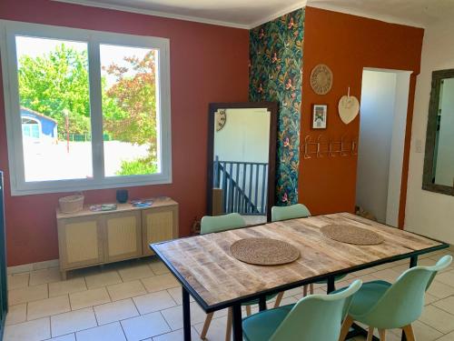 a dining room with a table and chairs at La villa Jeanne- Charmante maison avec très belle terrasse couverte à 10 min du centre de Salies de Bearn in Lahontan