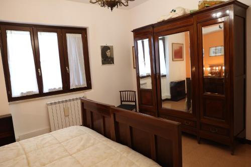a bedroom with a bed and a large wooden cabinet at Villa Pina in Priverno