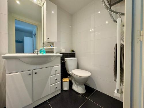 a white bathroom with a toilet and a sink at Entre mer & piscine Maison familiale pour 6 in Brétignolles-sur-Mer
