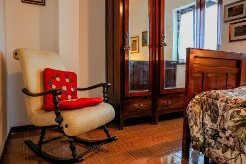 a chair with a red pillow in a bedroom at Villa Pina in Priverno